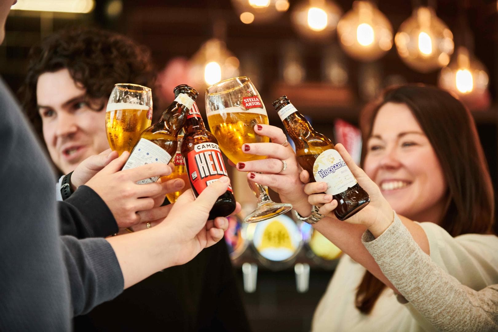 Group of people clinking their glasses of beer together