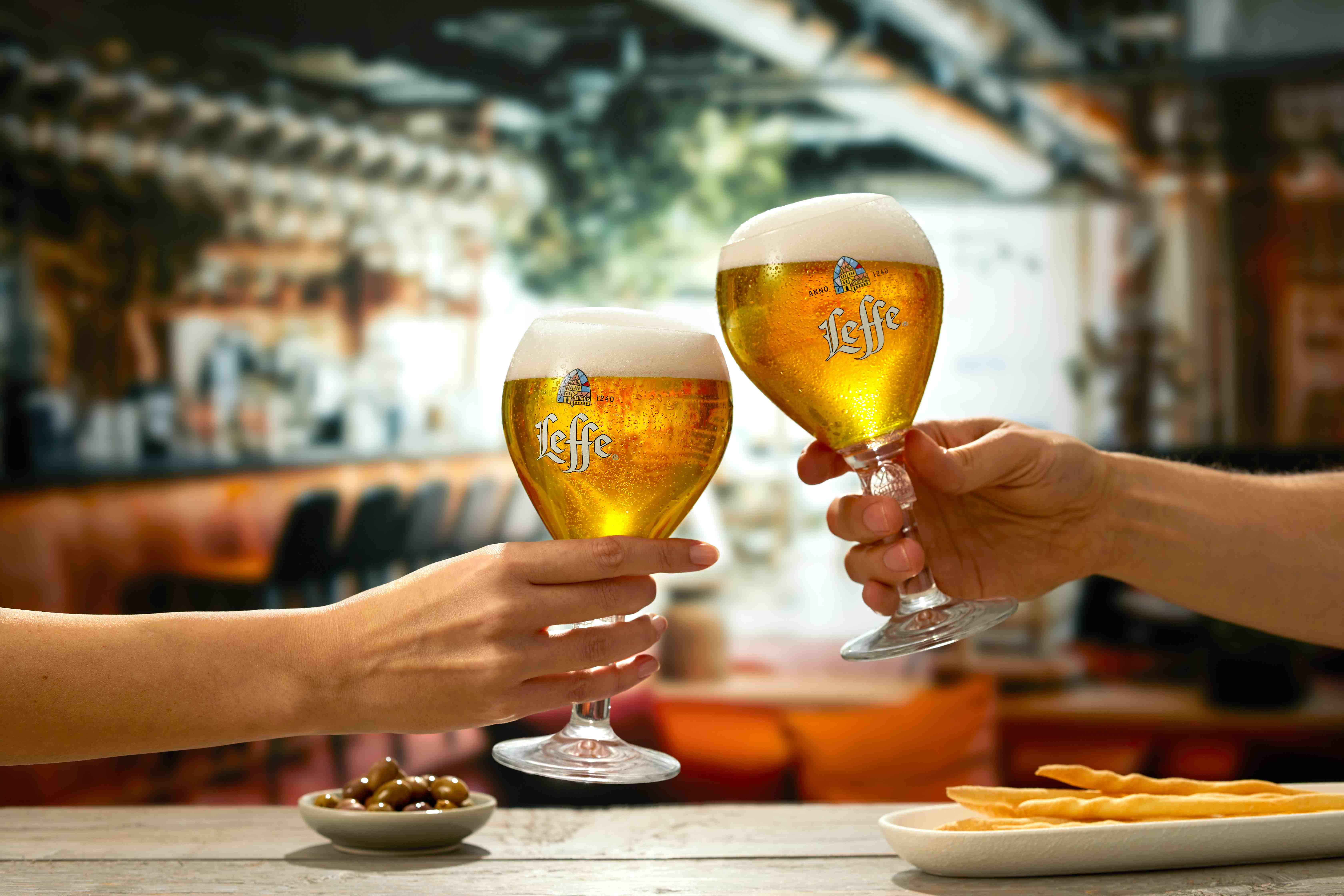 Two Leffe pint glasses being raised